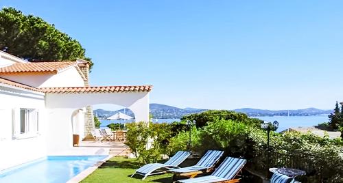 een villa met een zwembad en uitzicht op de oceaan bij Hôtel Villa Maya - Golfe de Saint-Tropez in Saint-Tropez