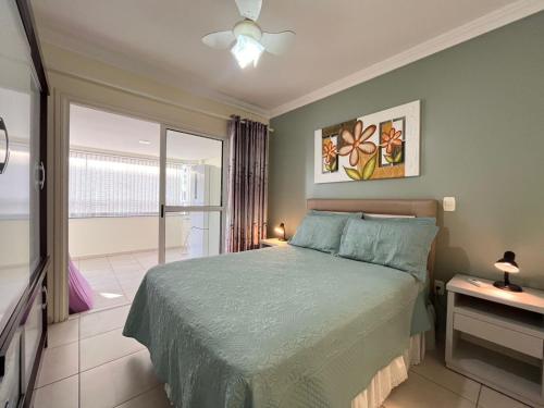 ein Schlafzimmer mit einem Bett und einem großen Fenster in der Unterkunft Ótima Localização!!! Apartamento De Frente No Centro De Capão Da Canoa in Capão da Canoa