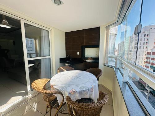 Zimmer mit einem Tisch und Stühlen auf einem Balkon in der Unterkunft Ótima Localização!!! Apartamento De Frente No Centro De Capão Da Canoa in Capão da Canoa