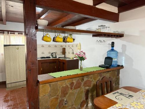 een keuken met een aanrecht en een tafel en een keuken met gele potten bij Cabaña Virginia in Samaipata