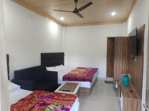 ein Zimmer mit zwei Betten und einem Flachbildfernseher in der Unterkunft Hotel Lake View Paradise in Uttarkāshi