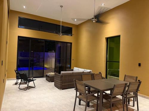 een woonkamer met een tafel, stoelen en een bank bij Casa Colibrí in Zipolite