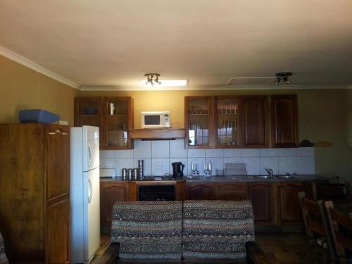 een keuken met houten kasten en een witte koelkast bij Ballito Vaca Home - KZN SA in Ballito