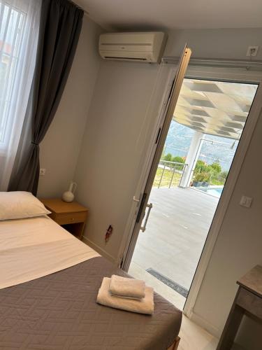 una camera da letto con un letto e una porta su un patio di Villa Amantia a Kouvaláta