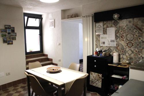 a kitchen with a table and chairs in a room at Casa Don Raffaele in Agira