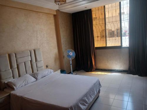een slaapkamer met een bed, een ventilator en een raam bij 锦鲤JinLi Central in Casablanca