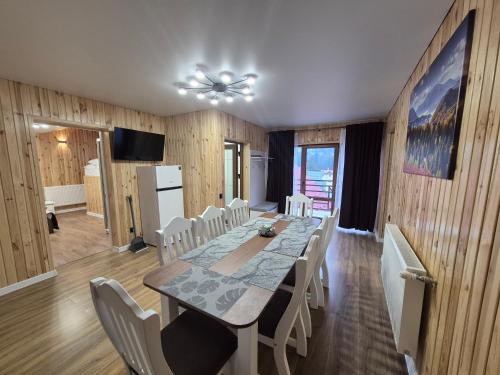 un comedor con una mesa larga y sillas blancas en Melody Hotel, en Bukovel