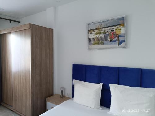 a bedroom with a bed with a blue headboard at TIM Haute standing appartment S2, center Monastir in Monastir