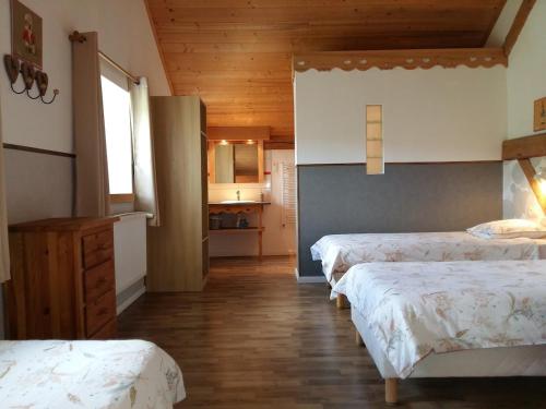 een kamer met drie bedden en een keuken in een huis bij L'Escapade gîte proche des Cascades du Hérisson in La Celle-sous-Gouzon