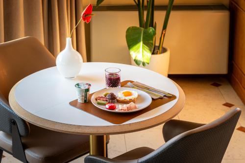 een tafel met een bord met ontbijt erop bij Hotel San Clemente in Santarcangelo di Romagna