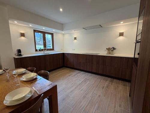 een eetkamer met een tafel en een keuken bij Chalet Les Ecrins in Vénosc