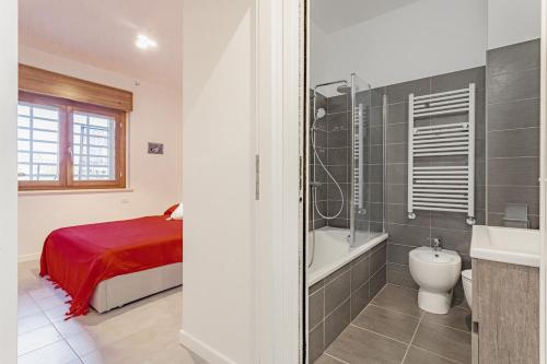 a bedroom with a bed and a bathroom with a bath tub at La casa di Plinio in Infernetto