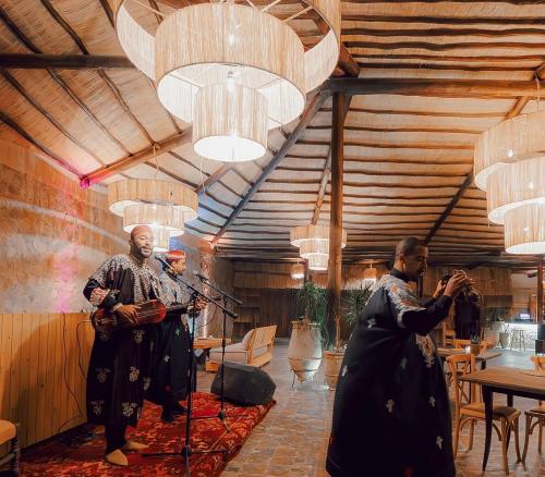 een groep mannen die instrumenten bespelen in een kamer bij Agafay Private evening camel ride sunset dinner show private experience in Marrakesh