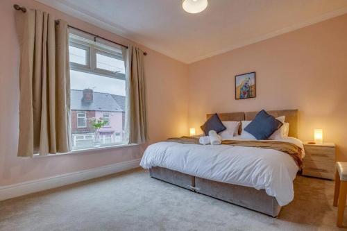 a bedroom with a bed and a large window at Manor Castle View 3BR House Free Parking & Garden in Victoria