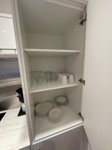 a closet with plates and dishes on shelves at Manor Castle View 3BR House Free Parking & Garden in Victoria