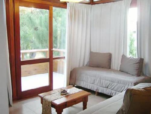 Una sala de estar con un sofá y una mesa de café. en Cabañas Arenas Blandas, en Villa Gesell