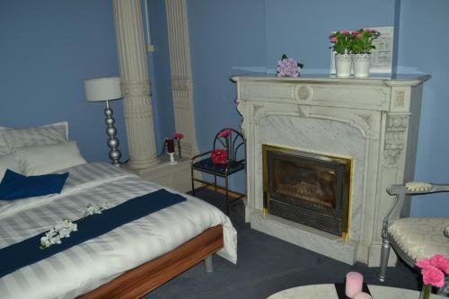um quarto com uma cama e uma lareira em Hotel Het Gasthof em Herent