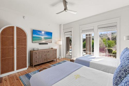una camera da letto bianca con due letti e una TV di 37 Compass Point South #107 a Watersound Beach