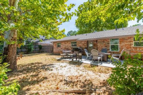 een stenen huis met een tafel en stoelen in een tuin bij Stadium Oasis in Arlington