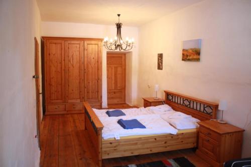 Schlafzimmer mit einem Bett mit weißer Bettwäsche und einem Kronleuchter in der Unterkunft Bruggerhaus in Schöder