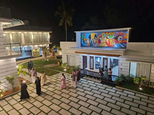 een groep mensen die 's nachts buiten een gebouw staan bij Palm Wave Beach Resort in Cochin