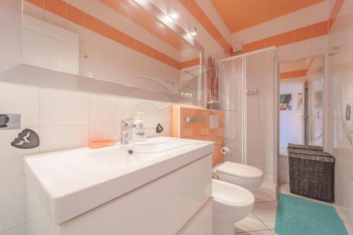 een badkamer met een witte wastafel en een toilet bij Il Porto 19 - Goelba in Porto Azzurro