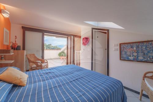 een slaapkamer met een bed met een blauw dekbed bij Il Porto 19 - Goelba in Porto Azzurro