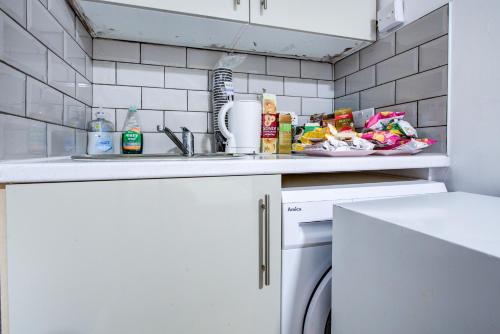 a kitchen counter with a sink and a dishwasher at Bryanston Camden Hotel in London