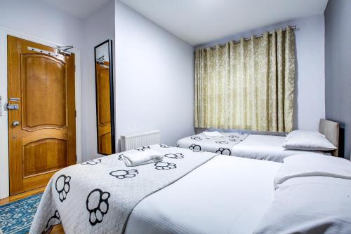 two twin beds in a room with a door at Bryanston Camden Hotel in London
