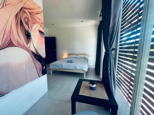 een kamer met een bed, een tafel en een raam bij HulaFling Homestay in Ban Bo Han