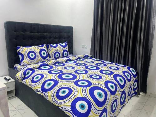 uma cama com um edredão e almofadas azuis e brancas em Deluxe One Bedroom Apartment em Ikeja