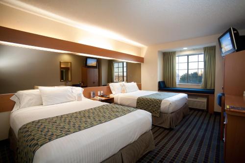 Un pat sau paturi într-o cameră la Microtel Inn & Suites by Wyndham Chihuahua