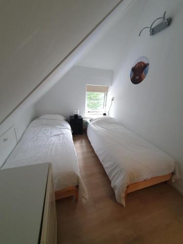 two beds sitting next to each other in a bedroom at Boshuis 40 in Epe