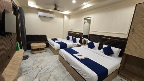 um quarto de hotel com duas camas e um sofá em Hotel Pinaki em Ajmer