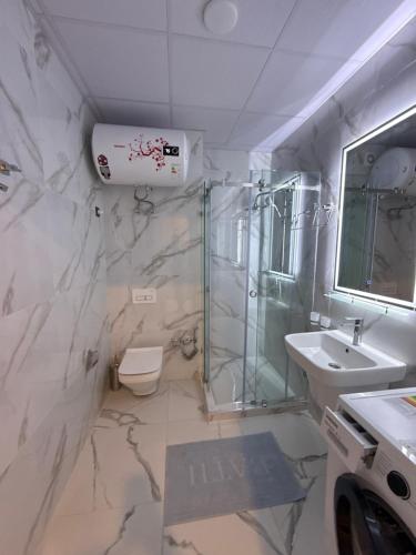 une salle de bains avec douche, toilettes et lavabo dans l'établissement Ugam revers Apartments, à Khumson