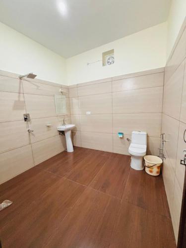 a bathroom with a toilet and a sink at Jim Corbett Guest House in Jhirna