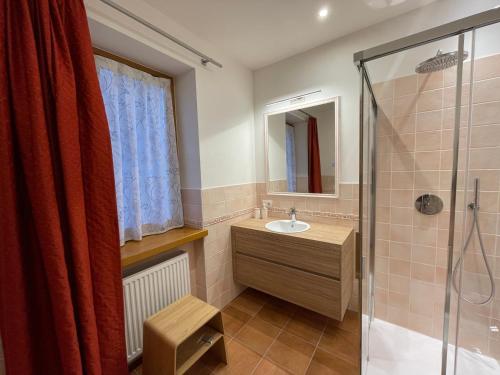 een badkamer met een wastafel en een douche bij Luna Rossa Dolomiti in Domegge di Cadore