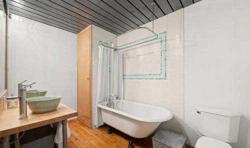 a bathroom with a tub and a toilet and a sink at Sun-Filled Luxury Historic 2 Bedrooms apto in New York