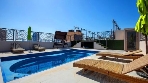 Una piscina con dos sillas y un patio. en City Point Hotel, en Manama