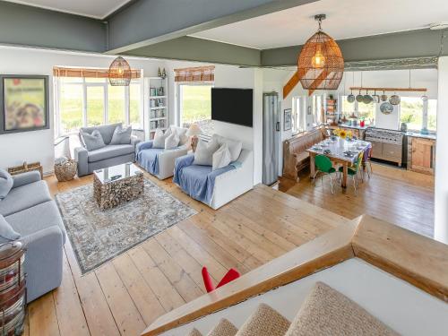 een woonkamer met blauwe banken en een keuken bij Lower Hendra Cottage in Port Isaac