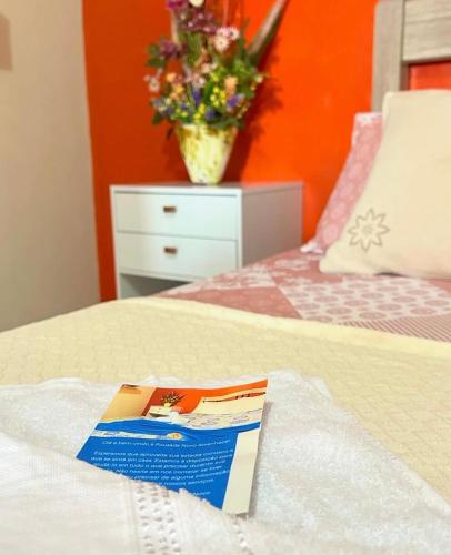 un libro seduto sopra un letto di Pousada Novo Amanhecer a Itarema