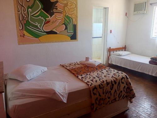 een kamer met twee bedden en een schilderij aan de muur bij Hotel Car in Rio Grande