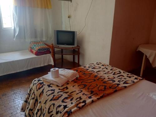 een kamer met een bed en een tv en een kamer met een bed gmaxwell gmaxwell bij Hotel Car in Rio Grande