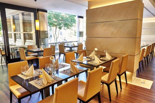 a restaurant with tables and chairs in a room at Steigenberger Hotel Köln in Cologne