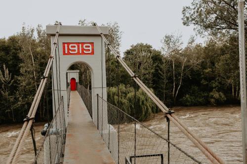 a bridge over a river with a red door at Gegund Guest Accomodation in Parys