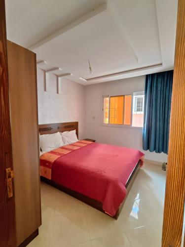 een slaapkamer met een groot bed met een rode deken bij Golden Home Tamraght in Tamraght Ouzdar