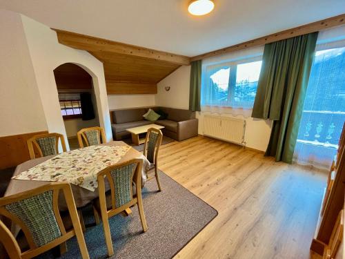 a living room with a table and chairs and a couch at Ferienwohnungen Luxner in Fügen