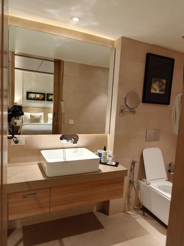 a bathroom with a sink and a mirror at Royal Hometel Suites in Mumbai