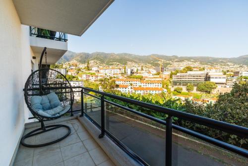 balkon z krzesłem i widokiem na miasto w obiekcie Design Gardens Nº2 w mieście Bicas