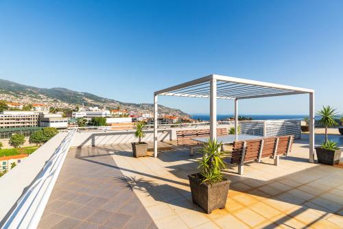 pawilon z ławkami i widokiem na ocean w obiekcie Design Gardens Nº2 w mieście Bicas